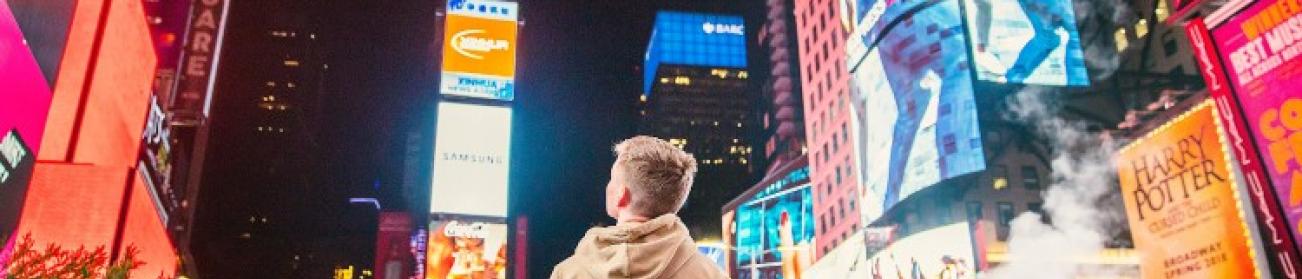 Jeune homme au milieu de panneaux publicitaires Jeune homme au milieu de panneaux publicitaires